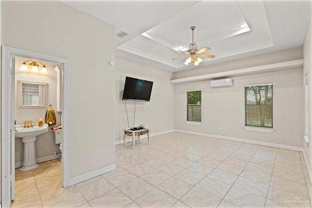 1800 E 24th St, Mission, TX 78574 - unfurnished living room with an AC wall unit, a tray ceiling, visible vents, and light tile patterned floors