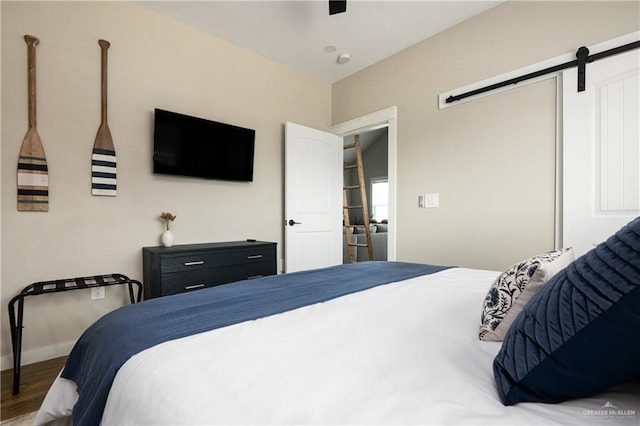 1053 Johnson Rd, Santa Fe, TX 77617 - bedroom with a barn door, wood finished floors, and ceiling fan