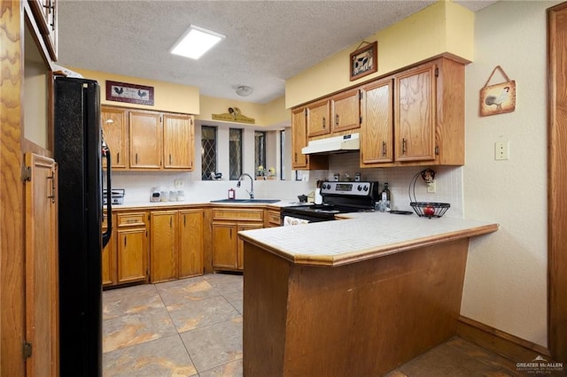 2403 Silver Oak Ave, Mission, TX 78574 - kitchen featuring a peninsula, a sink, stainless steel electric range oven, freestanding refrigerator, and under cabinet range hood