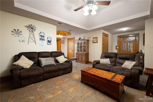 2403 Silver Oak Ave, Mission, TX 78574 - living room with a tray ceiling, baseboards, visible vents, ceiling fan with notable chandelier, and stone finish floor