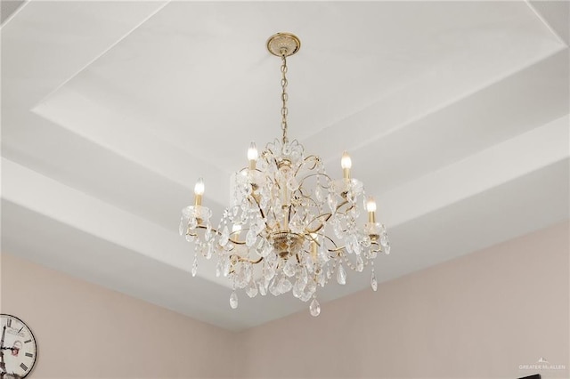 room details with a raised ceiling and an inviting chandelier