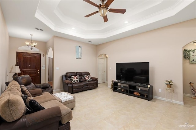 living room featuring ceiling fan with notable chandelier and a raised ceiling