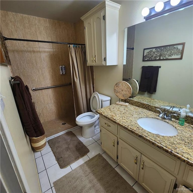 full bath featuring tiled shower, vanity, toilet, and tile patterned floors