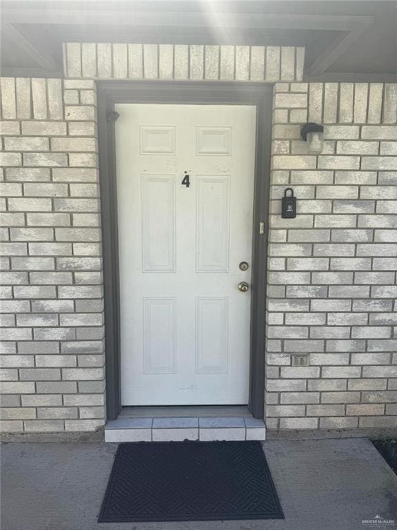 property entrance with a shingled roof