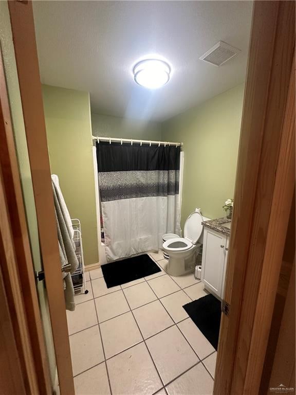 bathroom featuring toilet, vanity, and tile patterned floors