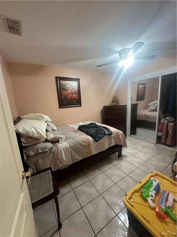 tiled bedroom featuring ceiling fan