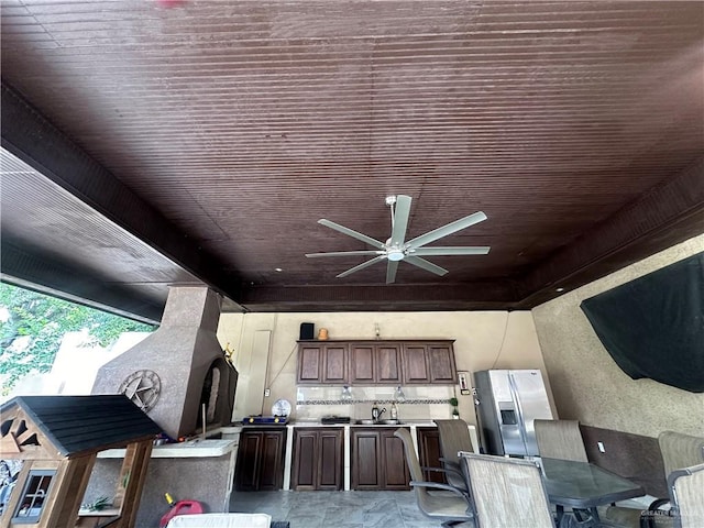 exterior space featuring wooden ceiling, sink, stainless steel fridge with ice dispenser, ceiling fan, and dark brown cabinetry