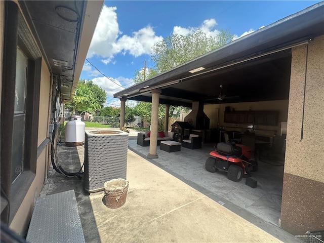 view of patio / terrace featuring an outdoor living space, ceiling fan, and central AC