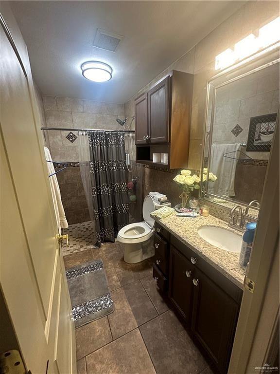 bathroom with tile patterned floors, a shower with curtain, toilet, and vanity