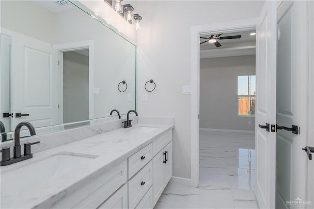 bathroom featuring marble finish floor, double vanity, a sink, and baseboards