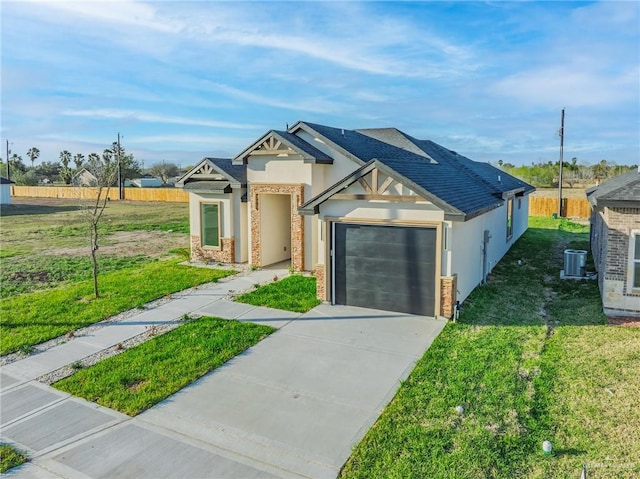 view of front facade with a garage, central AC, driveway, stucco siding, and a front lawn