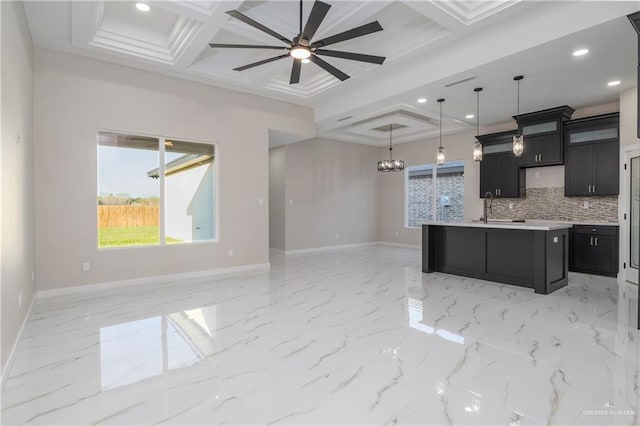 kitchen with open floor plan, coffered ceiling, and dark cabinetry