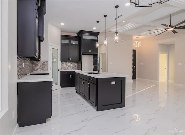 kitchen featuring recessed lighting, a sink, marble finish floor, tasteful backsplash, and pendant lighting