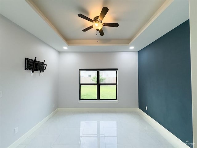 unfurnished room featuring ceiling fan and a tray ceiling