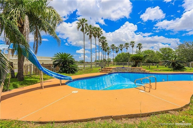 view of pool featuring a water slide and a patio