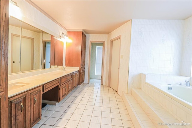 bathroom with tile patterned floors, vanity, crown molding, and tiled bath