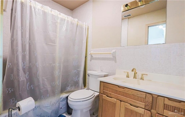 bathroom with vanity, toilet, tile walls, and walk in shower