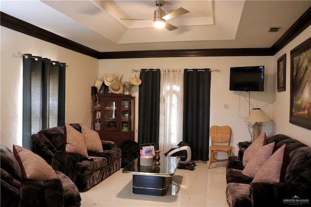 living room with a tray ceiling, ceiling fan, and ornamental molding