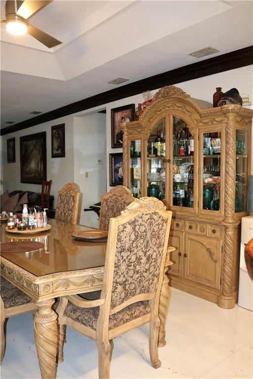 dining space featuring ceiling fan and ornamental molding