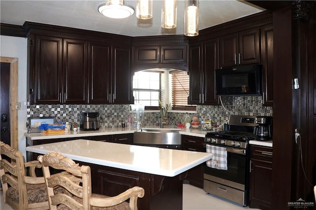 kitchen featuring sink, backsplash, pendant lighting, a breakfast bar area, and stainless steel stove