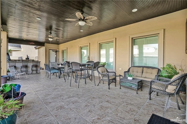 view of patio with exterior bar, ceiling fan, and an outdoor hangout area