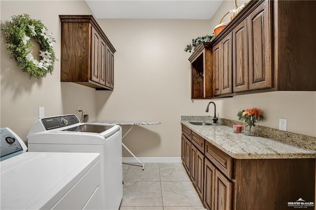 washroom with light tile patterned flooring, cabinets, sink, and washer and dryer