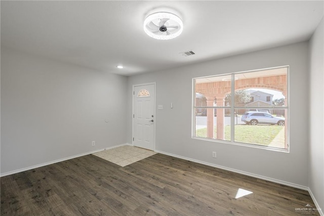 foyer featuring visible vents, baseboards, and wood finished floors