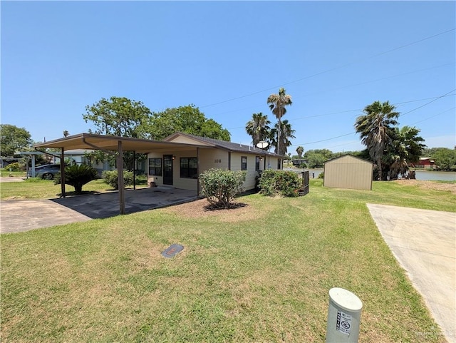 106 Resaca Shores Dr S, Los Fresnos, TX 78566 - view of front of house with driveway, a front lawn, an attached carport, an outbuilding, and a shed