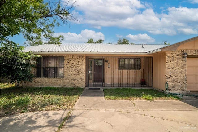 1207 Dolores Del Rio Ave, Mission, TX 78572 - view of front of property with brick siding, an attached garage, and metal roof