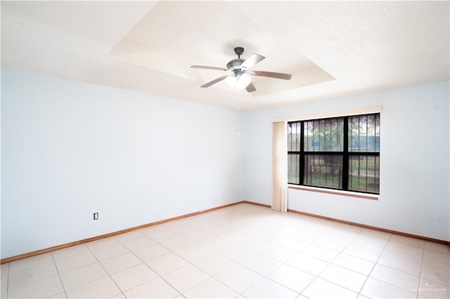 1207 Dolores Del Rio Ave, Mission, TX 78572 - unfurnished room with a tray ceiling, a ceiling fan, baseboards, and a textured ceiling