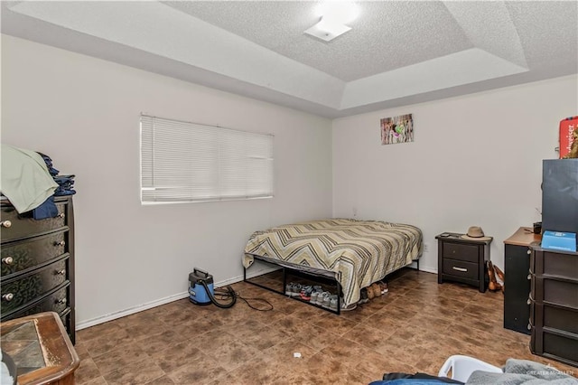 bedroom featuring a textured ceiling and a raised ceiling