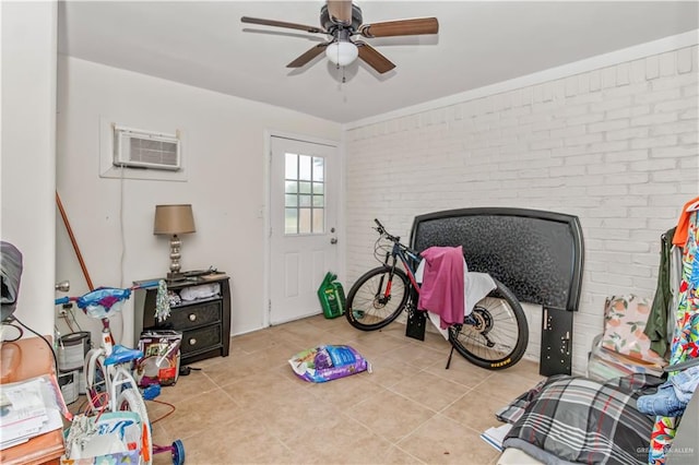 rec room with a wall mounted AC, ceiling fan, light tile patterned floors, and brick wall