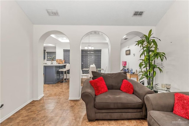 tiled living room featuring a notable chandelier