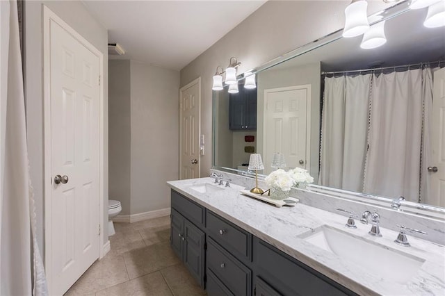 bathroom with tile patterned flooring, vanity, and toilet