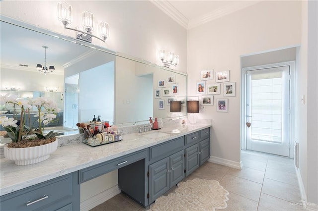 bathroom with tile patterned floors, vanity, ornamental molding, and an inviting chandelier