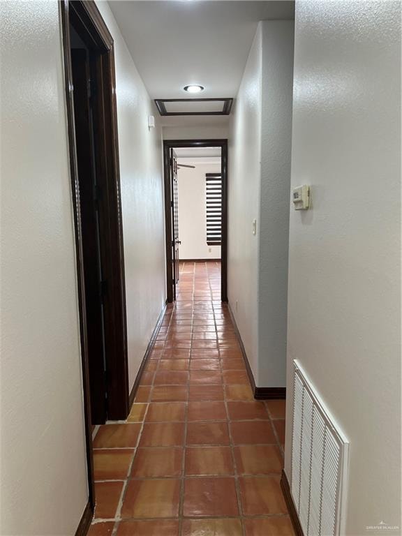 hallway featuring dark tile patterned floors