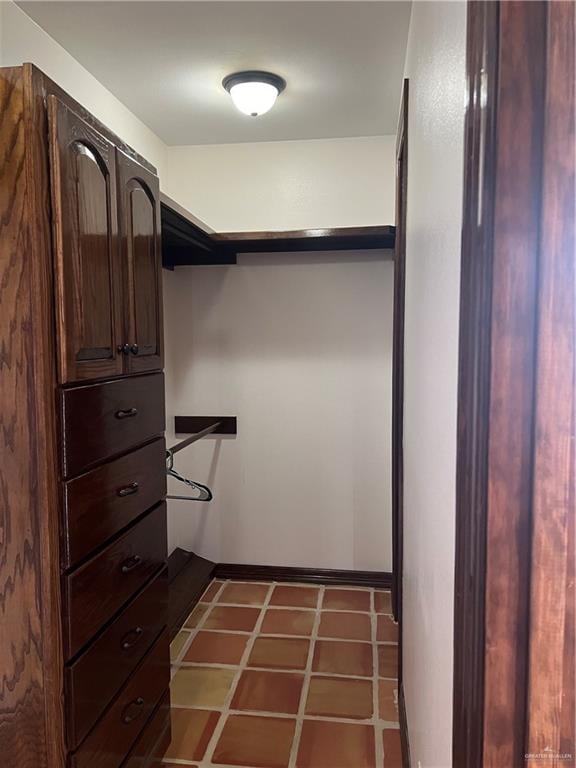 walk in closet featuring dark tile patterned flooring