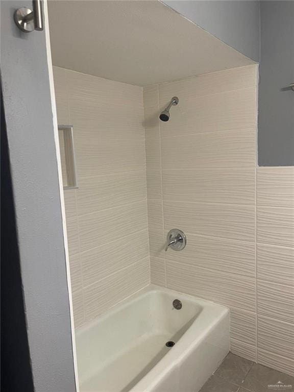 bathroom featuring tile patterned flooring, tiled shower / bath, and tile walls