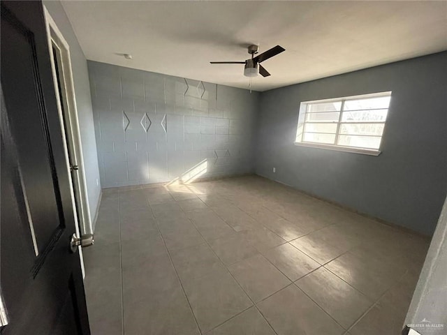 tiled empty room with ceiling fan