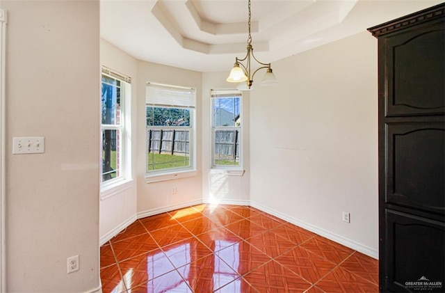 unfurnished dining area with a raised ceiling and a notable chandelier