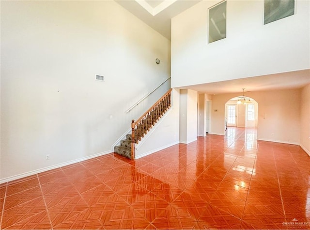 interior space with a towering ceiling and tile patterned flooring