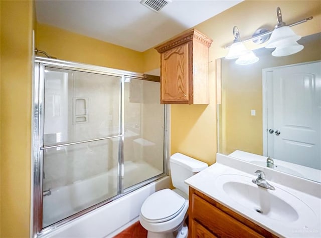 full bathroom featuring toilet, enclosed tub / shower combo, and vanity