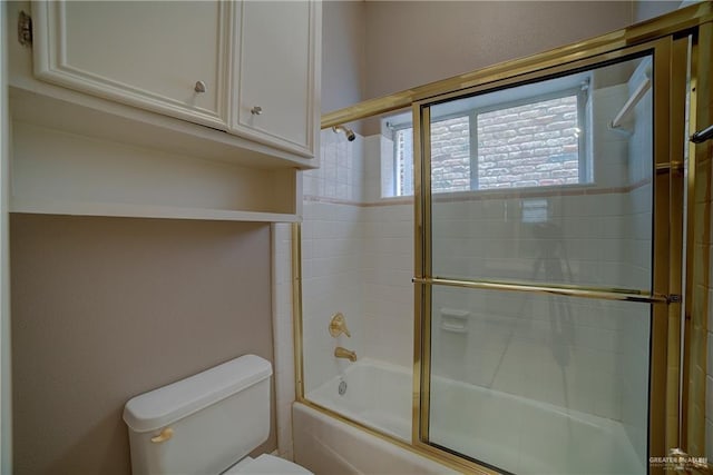 bathroom featuring toilet and combined bath / shower with glass door