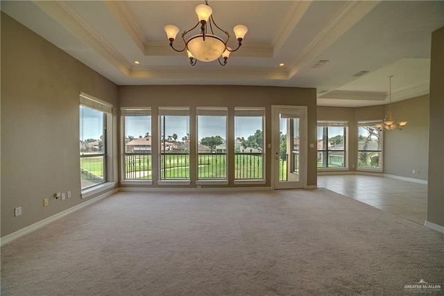 carpeted empty room with a tray ceiling, crown molding, and a notable chandelier