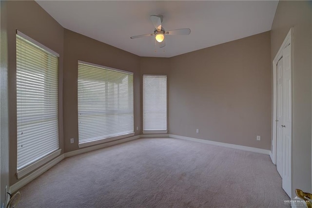 carpeted spare room with ceiling fan