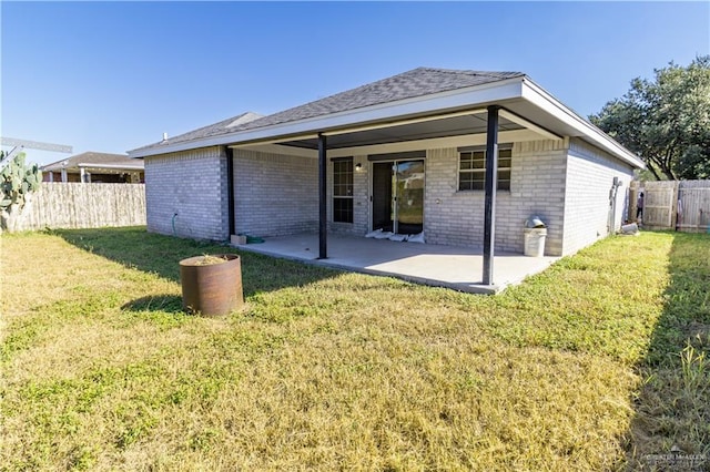 rear view of property with a yard and a patio