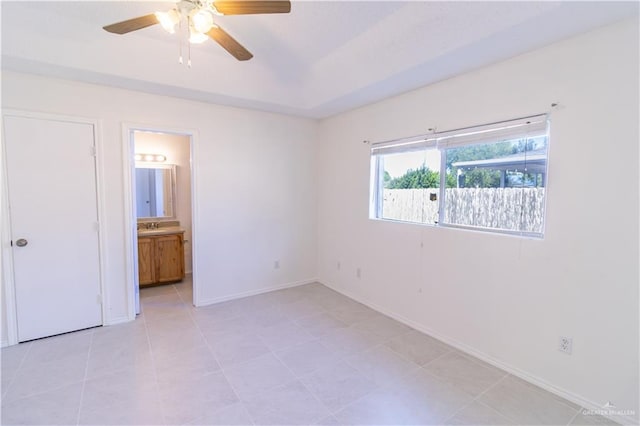 unfurnished bedroom with ensuite bath, ceiling fan, and sink