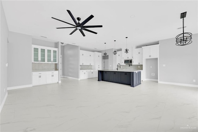 1915 Chandler Cir, Edinburg, TX 78542 - kitchen featuring stainless steel microwave, light marble finish floors, backsplash, and ceiling fan