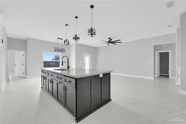 1915 Chandler Cir, Edinburg, TX 78542 - kitchen with light marble finish floors, ceiling fan, light countertops, and an island with sink
