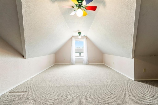 bonus room with vaulted ceiling, a textured ceiling, carpet, and baseboards